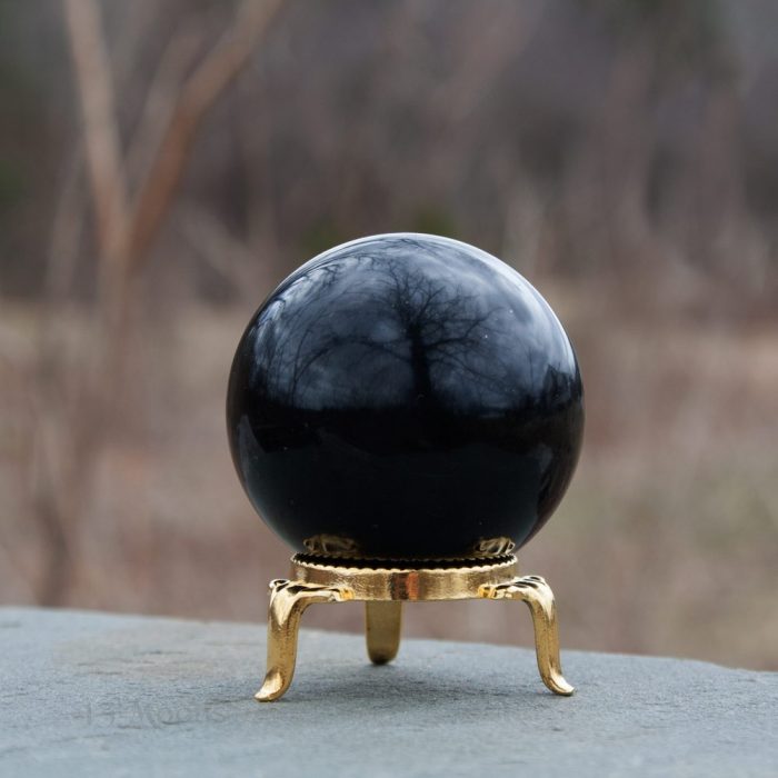 Bola negra de obsidiana en soporte dorado