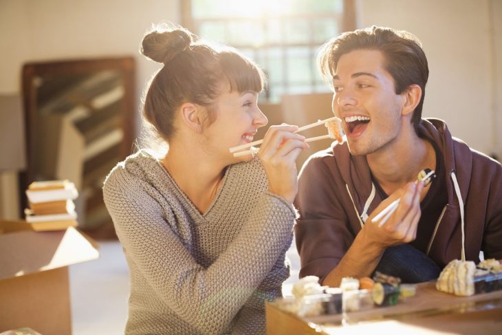 Mujer compartiéndole de su comida a su pareja