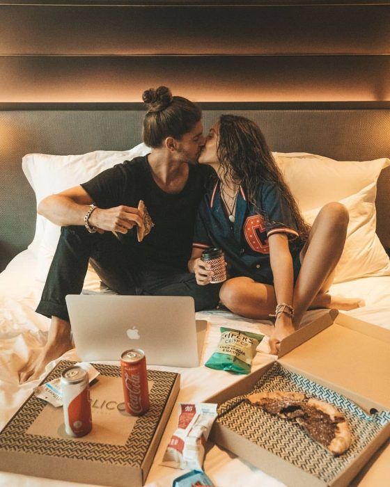 Pareja de enamorados comiendo pizza y chucherías