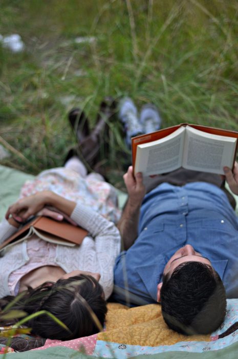 Pareja leyendo en el pasto