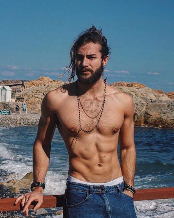 Hombre con barba posando frente al mar