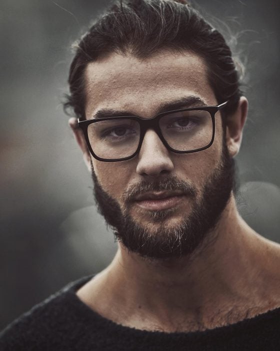 Hombre modelo con lentes y barba posando