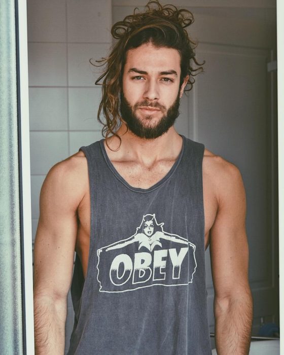 Hombre de cabello largo y barba posando para foto