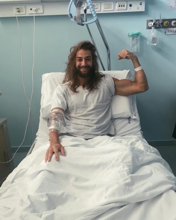 Hombre de cabello largo y barba en una cama de hospital