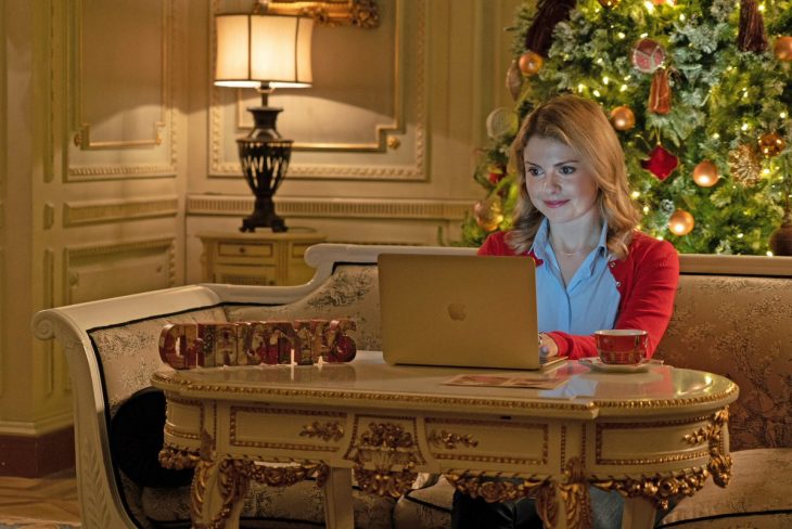 mujer rubia con computadora y árbol de navidad 