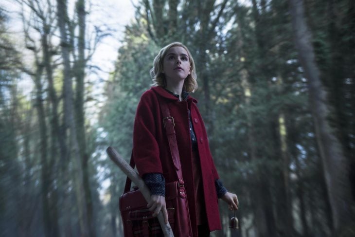 Chica con capa roja caminando en medio del bosque