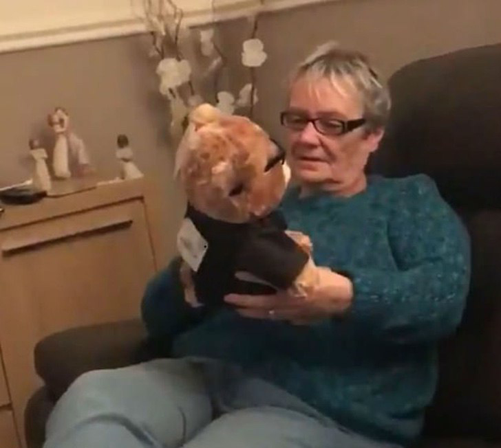 Abuela sosteniendo a un oso con voz en sus manos 