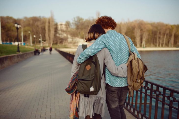 Pareja de enamorados camina abrazada