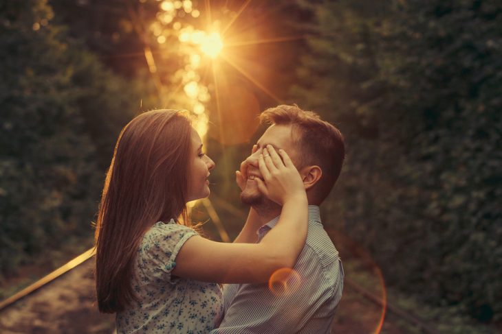 Mujer le tapa los ojos a su enamorado en el bosque