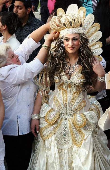 mujer con vestido blanco dorado y corona 