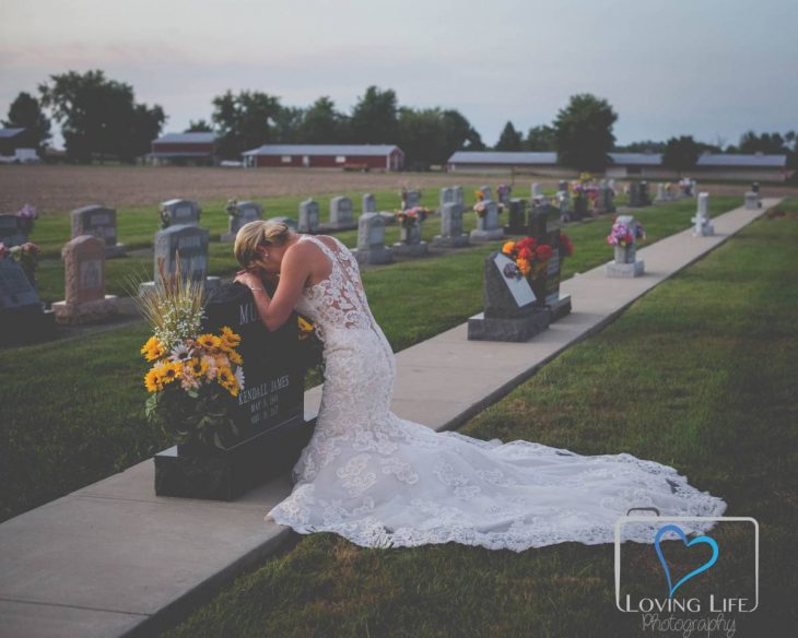 Chica vestida de novia llorando frente a la tumba de su prometido 