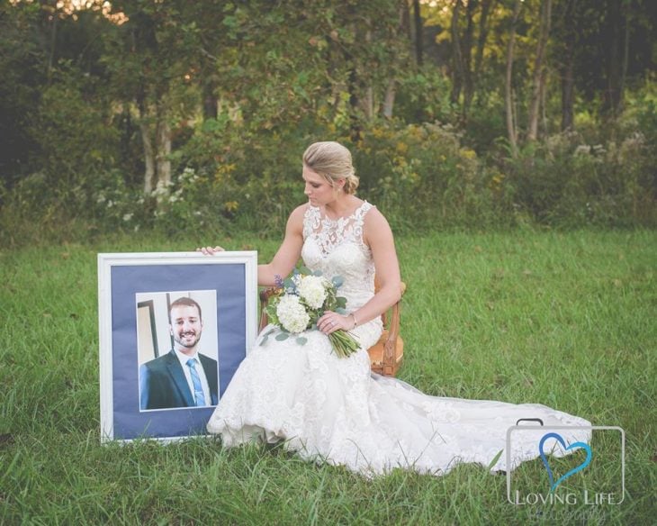 Chica vestida de novia sosteniendo una foto de su novio fallecido