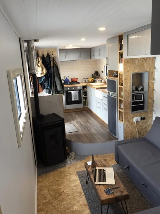 camión remodelado para convertirse en una casa con sillones cocina y comedor