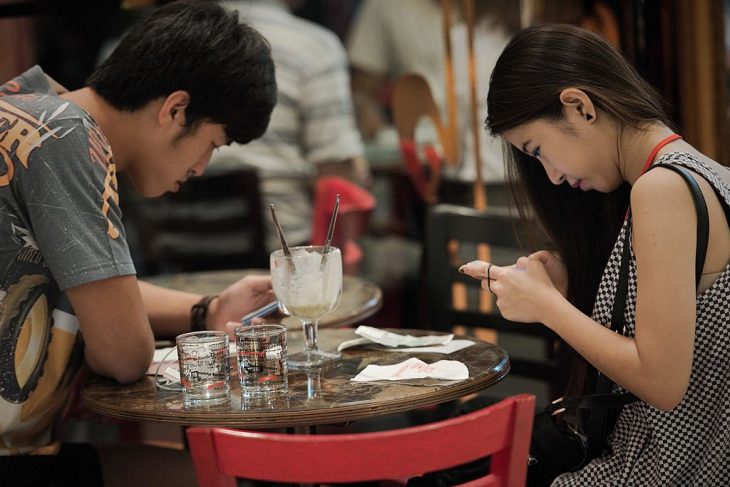 Pareja revisando su celular durante una cita
