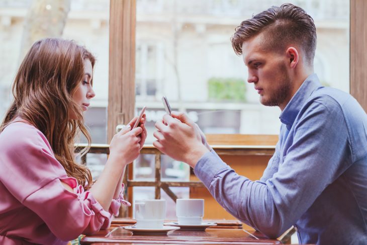 Pareja revisando su celular durante una cita