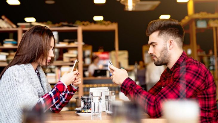 Pareja revisando su celular durante una cita