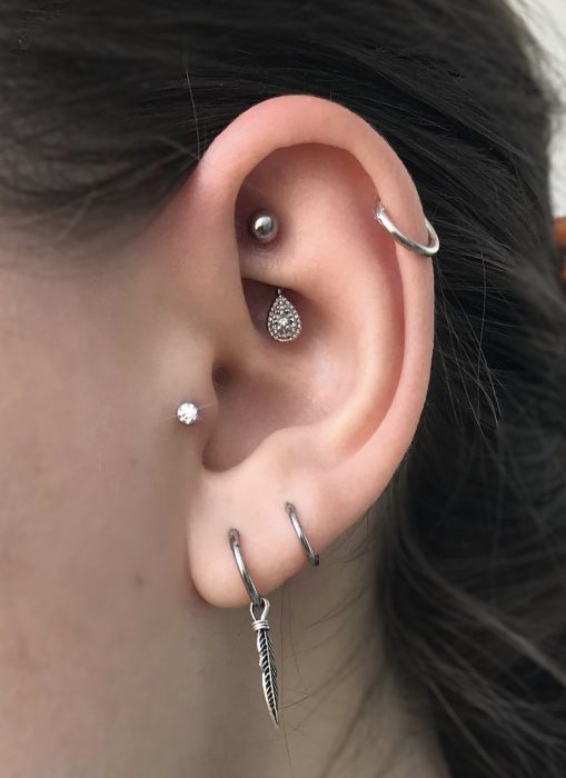 Oreja de chica con más de un piercing