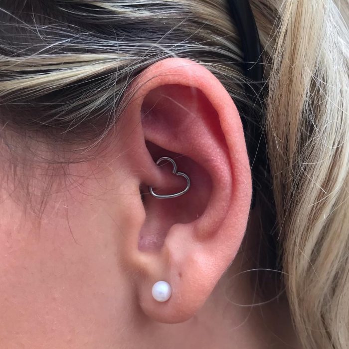 Oreja de chica con más de un piercing