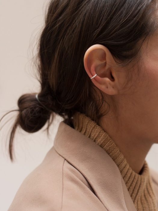 Oreja de chica con más de un piercing