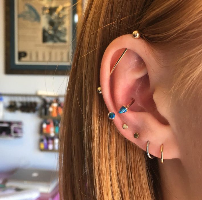 Oreja de chica con más de un piercing