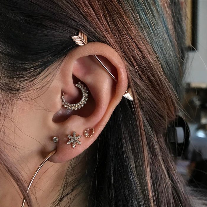 Oreja de chica con más de un piercing