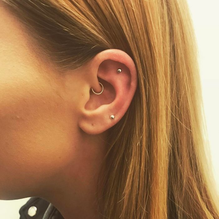 Oreja de chica con más de un piercing