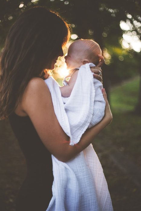 mamá cargando a su bebé en brazos 