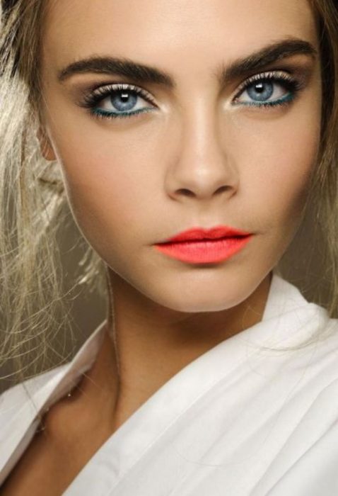 Cara Delevigne usando un maquillaje marcado y labios de color coral