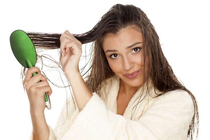 mujer con cabello mojado cepillando 