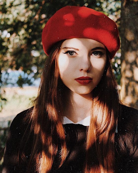 mujer con boina roja y vestido negro 