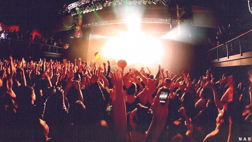 manos saltando y escenario en concierto 