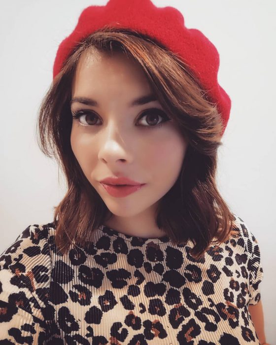 mujer con boina roja y blusa de leopardo 