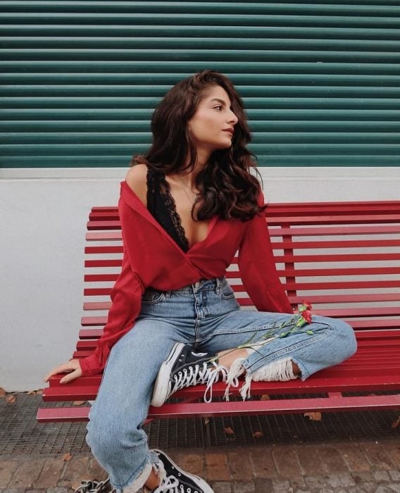 mujer con pantalones de mezclilla y blusa roja 