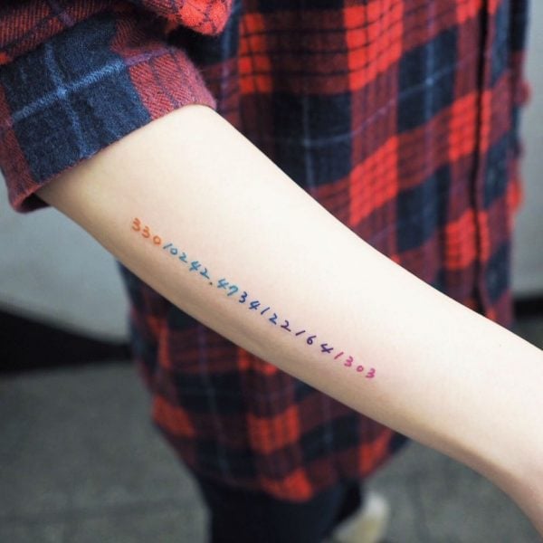 brazo de mujer blanco con letras de colores 