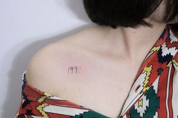 numero fecha de año escrita tatuada en clavícula 