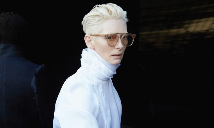 Mujer de cabello blanco, lentes de sol y abrigo blanco