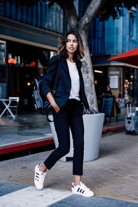 mujer con pantalon negro playera blanca y blazer 