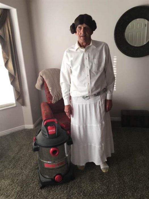 Abuelo disfrazado de princesa Leia junto a una apsiradora