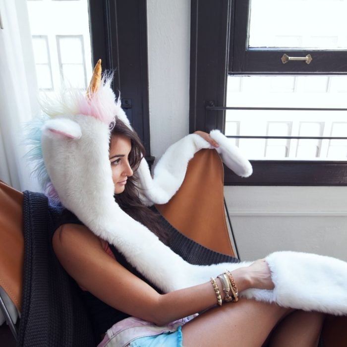 Chica usando gorro de unicornio con guantes integrados