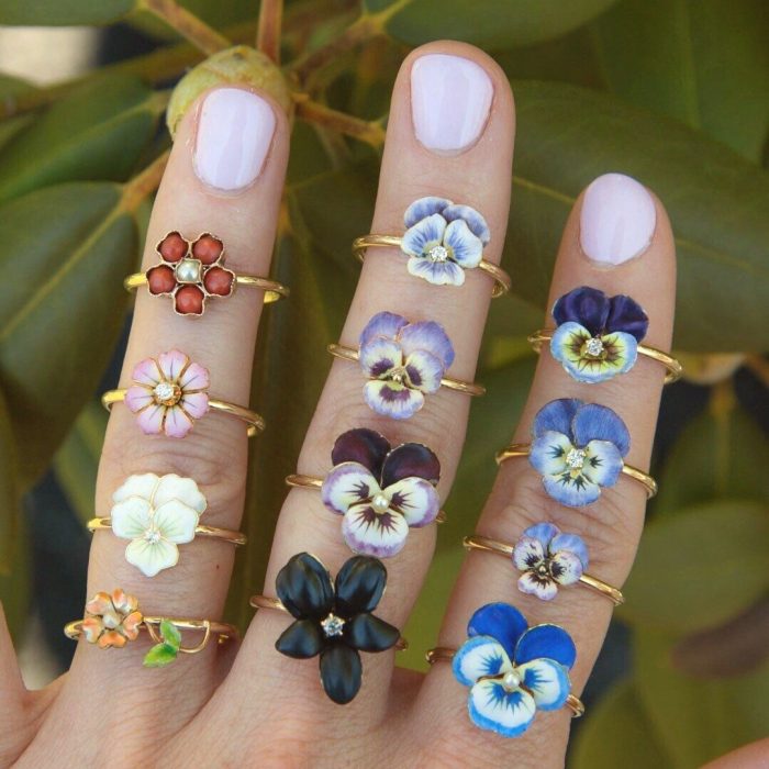 Mano de mujer con anillos en forma de flores