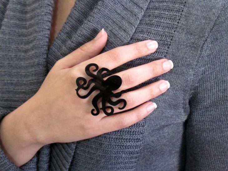 Mano de mujer con anillo de pulpo negro