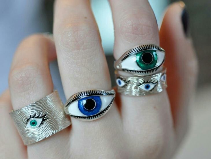 Mano de mujer con anillos en forma de ojos