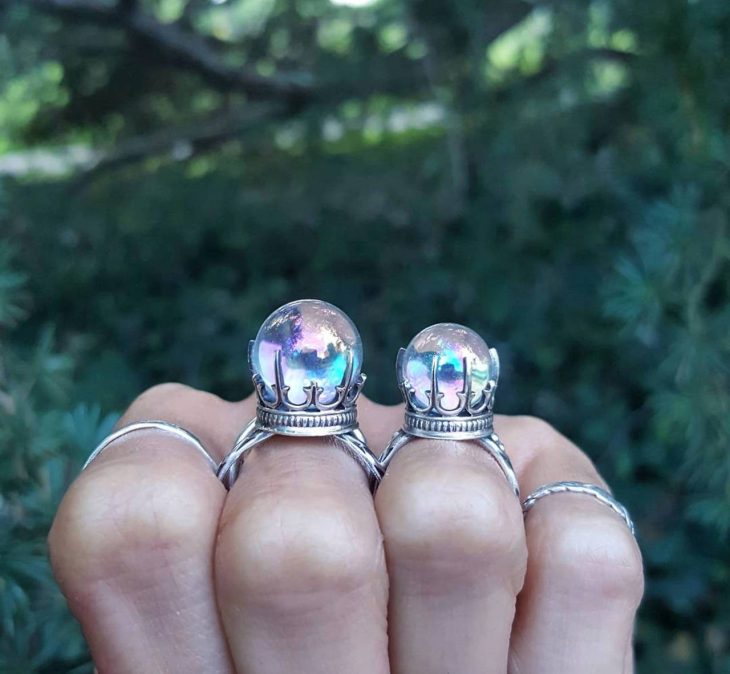 Mano de mujer con anillos en forma de bola de cristal