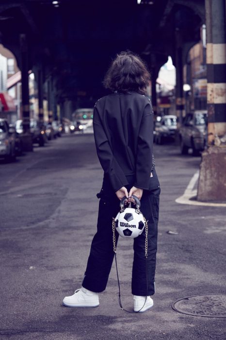 Chica sosteniendo un bolso hecho con pelota de futbol