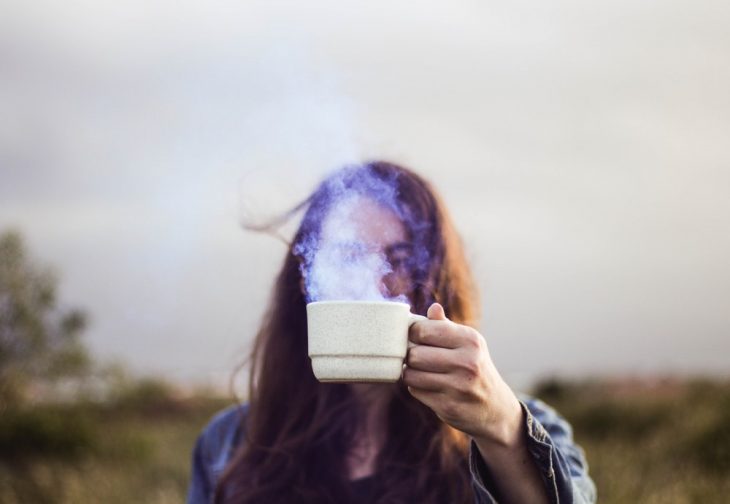 chica sosteniendo na taza de café