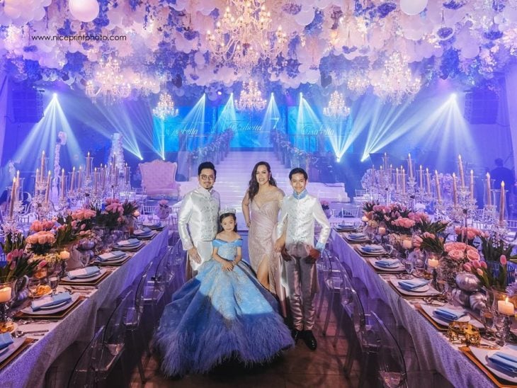 niña con vestido azul y corona en fiesta y familia