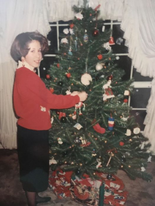 Niña que parece señora colocando el árbol de navidad en los 90