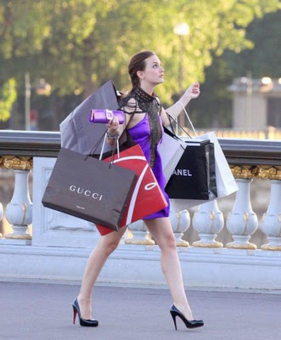 chica llevando bolsas de papel en la manos