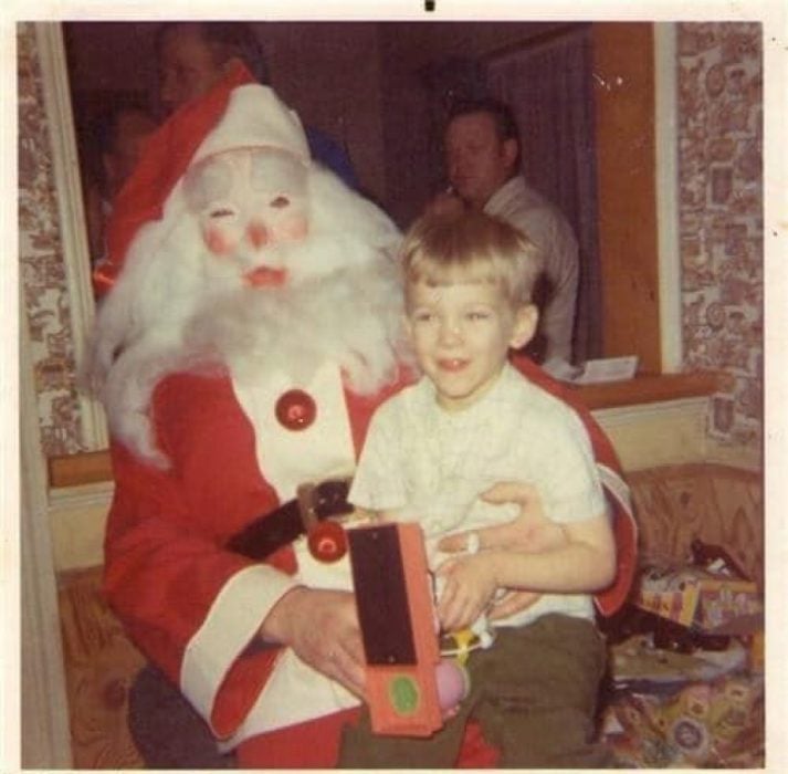 Santa Claus que da miedo cargando a un niño