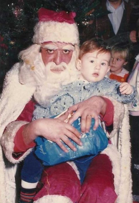 Santa Claus que da miedo cargando a un niño